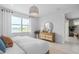 Bright main bedroom featuring large windows, natural light, an en-suite bath, and stylish woven furniture at 2338 Lily Bloom Rd, St Cloud, FL 34771