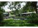 Waterfront backyard with boat dock featuring green grass, mature trees, and ample space at 2417 Bayfront Pkwy, Orlando, FL 32806