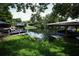 Lush waterfront backyard featuring boat dock, green grass, and mature trees at 2417 Bayfront Pkwy, Orlando, FL 32806
