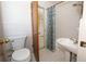 Bathroom featuring a toilet and sink and shower-tub combo with floral curtain at 2417 Bayfront Pkwy, Orlando, FL 32806
