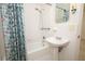 Clean bathroom with a pedestal sink, shower-tub combo, and a floral shower curtain at 2417 Bayfront Pkwy, Orlando, FL 32806