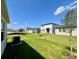 Spacious backyard showcasing lush green grass and some young trees under a clear blue sky at 2739 San Marco Way, Winter Haven, FL 33884