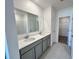 Bathroom with double sinks, white countertops, gray cabinets and a large mirror over the vanity at 2739 San Marco Way, Winter Haven, FL 33884