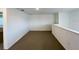 Carpeted bonus room with neutral colors, a single window, and a partial wall separating the stairs at 2739 San Marco Way, Winter Haven, FL 33884
