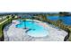 Aerial view of the community pool area with ample seating, palm trees, and a scenic view of the lake at 2739 San Marco Way, Winter Haven, FL 33884