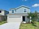 Charming two-story home with blue accents, a two-car garage, and a well-maintained front yard at 2739 San Marco Way, Winter Haven, FL 33884