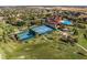Expansive aerial view of the community with tennis courts, pool, and clubhouse amidst green spaces at 3210 Sonesta Ct # B, Clermont, FL 34711