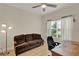 Comfortable bedroom with wood-look tile flooring, a ceiling fan and a bright window with sheer white curtains at 3210 Sonesta Ct # B, Clermont, FL 34711