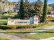 Elegant stone clubhouse sign surrounded by lush greenery and manicured landscaping at 3210 Sonesta Ct # B, Clermont, FL 34711