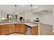 Kitchen with wood cabinetry, granite countertops, stainless appliances, and a breakfast bar that opens to the living room at 3210 Sonesta Ct # B, Clermont, FL 34711