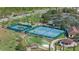 Overhead view of tennis courts, putting green, and other community amenities in a lush setting at 3210 Sonesta Ct # B, Clermont, FL 34711
