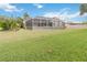 Large green backyard featuring screened-in patio and blue sky background at 3808 Ocita Dr, Orlando, FL 32837