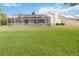 View of the screened-in patio with a large green lawn and blue skies at 3808 Ocita Dr, Orlando, FL 32837