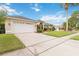 Beautiful single-story home featuring an attached two-car garage and lush landscaping with mature palm trees at 3808 Ocita Dr, Orlando, FL 32837