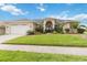 Charming home featuring a beautifully landscaped front yard, arched entryway, and a two-car garage at 3808 Ocita Dr, Orlando, FL 32837