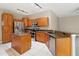 Modern kitchen with stainless steel appliances, an island, granite countertops, and wooden cabinetry at 3808 Ocita Dr, Orlando, FL 32837