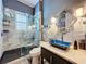Stylish bathroom with a glass shower, blue sink and decorative mirror at 4545 Fox St, Orlando, FL 32814