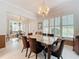 Formal dining area with a granite table, brown velvet chairs, and open to the living room with bright shutters at 4545 Fox St, Orlando, FL 32814