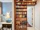 Hallway featuring a built in bookshelf and view into a half bathroom with a stylish blue sink at 4545 Fox St, Orlando, FL 32814