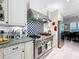 Updated kitchen with stainless steel stove, custom backsplash, and granite countertops at 4545 Fox St, Orlando, FL 32814