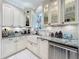Close-up of kitchen features a farmhouse sink, a stainless steel dishwasher, and granite countertops at 4545 Fox St, Orlando, FL 32814