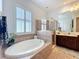 Bathroom with a double sink vanity, shower and soaking tub with a large window for natural light at 4545 Fox St, Orlando, FL 32814