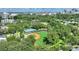 Expansive aerial view showcasing baseball and tennis courts, enveloped by verdant trees and a distant city skyline at 501 Richmond St, Orlando, FL 32806