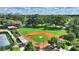 A large baseball field surrounded by mature trees with a clear sky in the background at 501 Richmond St, Orlando, FL 32806
