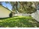 Backyard with lush green grass, mature trees, vinyl fencing and covered patio at 5334 Cypress Dr, Winter Park, FL 32792