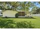 Spacious backyard showcasing green grass, mature trees, and a screened-in patio at 5334 Cypress Dr, Winter Park, FL 32792