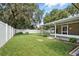 Expansive backyard with lush green grass, a white vinyl fence, and a covered patio at 5334 Cypress Dr, Winter Park, FL 32792