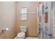 Cozy bathroom with toilet, shower, towel rack, and small window, designed for functionality and privacy at 5334 Cypress Dr, Winter Park, FL 32792
