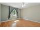 Bright bedroom featuring hardwood floors, a ceiling fan, and a window with light-filtering curtains at 5334 Cypress Dr, Winter Park, FL 32792