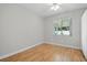 Bright bedroom with neutral walls, hardwood floors, and a window overlooking the backyard at 5334 Cypress Dr, Winter Park, FL 32792