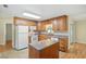Functional kitchen with an island, oak cabinets, and white appliances, perfect for meal preparation at 5334 Cypress Dr, Winter Park, FL 32792