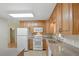 Bright kitchen features wood cabinets, white appliances, and neutral countertops, with natural light at 5334 Cypress Dr, Winter Park, FL 32792