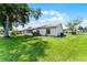 Spacious backyard with lush green lawn and mature trees, providing ample shade at 5439 E Sacramento Ct, Orlando, FL 32821