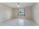 Bedroom featuring a ceiling fan, window, neutral wallpaper, and tile flooring at 5439 E Sacramento Ct, Orlando, FL 32821