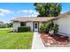 Inviting front entrance with well-maintained landscaping, a walkway, and charming seating area at 5439 E Sacramento Ct, Orlando, FL 32821