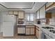 Kitchen with white appliances, wood cabinets, tile backsplash and flooring, and window at 5439 E Sacramento Ct, Orlando, FL 32821