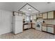 Functional kitchen featuring white appliances, tile countertops, and ample cabinet space for storage at 5439 E Sacramento Ct, Orlando, FL 32821