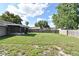 Backyard with a green lawn, partially-wood fenced perimeter, and screened porch at 5588 Garden Grove Cir, Winter Park, FL 32792