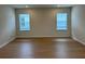 Spacious living area with hardwood floors and two windows providing ample natural light at 7408 Olivewood Ave, Orlando, FL 32829