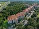 Scenic aerial view of a multi-story apartment complex surrounded by lush greenery and a nearby highway at 8020 Tuscany Way # 6301, Davenport, FL 33896