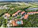 Overhead view of the condo community with lush landscaping, a pool, and beautiful buildings with red tile roofs at 8020 Tuscany Way # 6301, Davenport, FL 33896