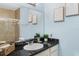 Well-lit bathroom featuring a granite vanity and a walk-in shower with glass door at 8020 Tuscany Way # 6301, Davenport, FL 33896