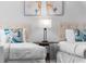 Close up on bedroom featuring hardwood floors, two twin beds, and a bedside table with a lamp at 8020 Tuscany Way # 6301, Davenport, FL 33896