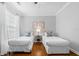 Comfortable bedroom featuring hardwood floors, two twin beds, and a bedside table with a lamp at 8020 Tuscany Way # 6301, Davenport, FL 33896