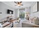 Bright living room featuring a ceiling fan, comfortable seating, and sliding glass doors to a balcony at 8020 Tuscany Way # 6301, Davenport, FL 33896
