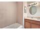 Compact bathroom featuring a tub, vanity with sink, and tiled walls, offering essential amenities at 830 N Sunset Dr, Mount Dora, FL 32757